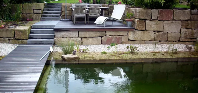 Gartenteich mit Holzterrasse, Stufen und Lounge-Möbeln